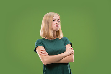 Image showing Suspiciont. Doubtful pensive woman with thoughtful expression making choice against green background