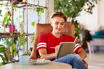 Image showing teenage girl with notebook at coffee shop or cafe