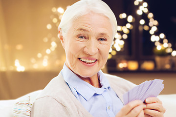 Image showing happy senior woman playing cards on christmas