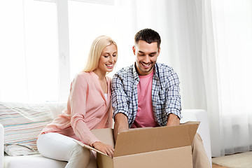 Image showing happy couple with open parcel box at home