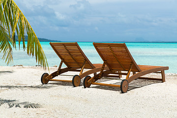 Image showing tropical beach with palm tree and sunbeds