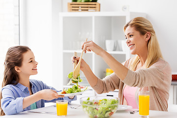 Image showing happy family eating salad at home kitchen