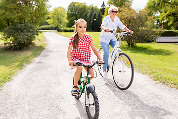 Image showing grandmother and granddaughter cycling at park