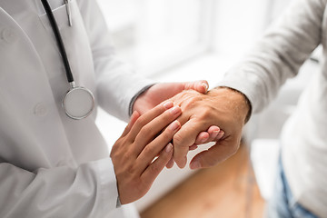 Image showing close up of doctor holding senior patient hand