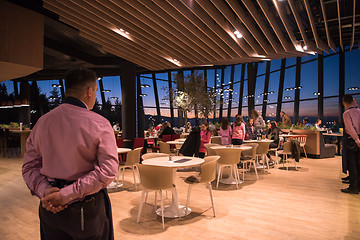 Image showing waiter standing with hands behind his back