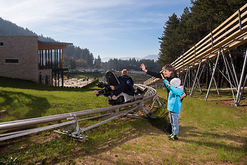 Image showing Happy family driving on alpine coaster