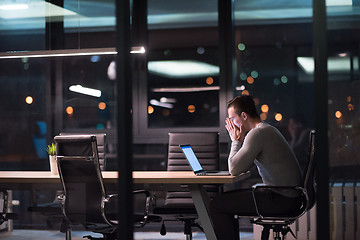 Image showing man working on laptop in dark office