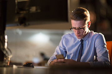 Image showing man using mobile phone in dark office