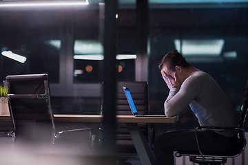 Image showing man working on laptop in dark office