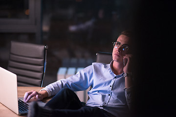 Image showing businessman using mobile phone in dark office