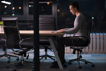 Image showing man working on laptop in dark office