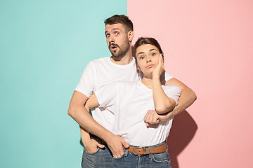 Image showing Wow. Doubtful pensive couple with thoughtful expression making choice against pink background