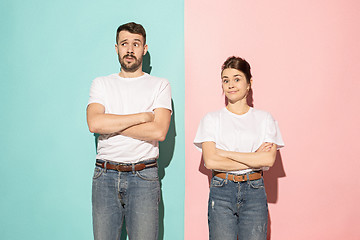 Image showing Let me think. Doubtful pensive couple with thoughtful expression making choice against pink background