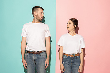 Image showing Wow. Doubtful pensive couple with thoughtful expression making choice against pink background