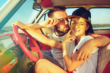 Image showing Laughing romantic couple sitting in car while out on a road trip at summer day