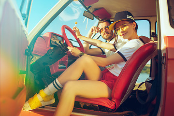 Image showing Laughing romantic couple sitting in car while out on a road trip at summer day