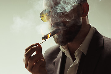 Image showing The barded man in a suit holding cigar