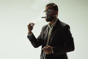 Image showing The barded man in a suit holding cigar