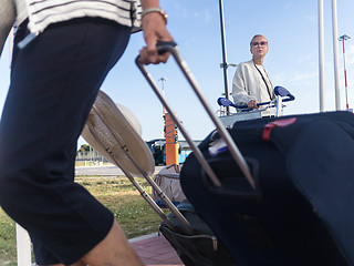 Image showing Young woman transporting luggage from arrival parking to international airport departure termainal by luggage trolley.