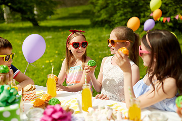 Image showing kids eating cupcakes on birthday party in summer