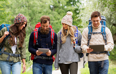 Image showing friends or travelers with backpacks and tablet pc