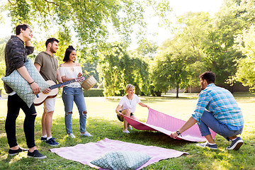 Image showing friends arranging place for picnic at summer park