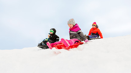 Image showing kids sliding on sleds down snow hill in winter