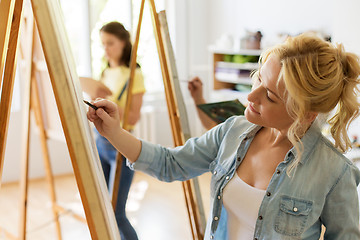 Image showing woman with easel drawing at art school studio