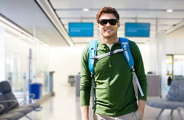 Image showing smiling man with backpack over airport terminal