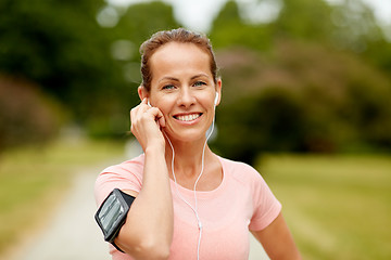 Image showing woman with earphones listening to music at park