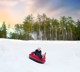 Image showing happy teenage girl sliding down hill on snow tube