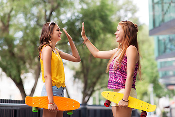 Image showing teenage girls with skateboards making high five