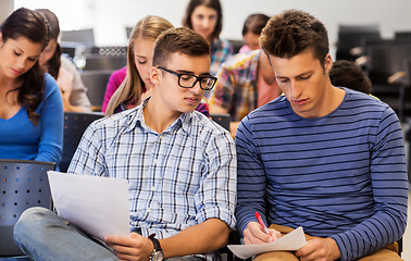 Image showing group of students with papers in lecture hall