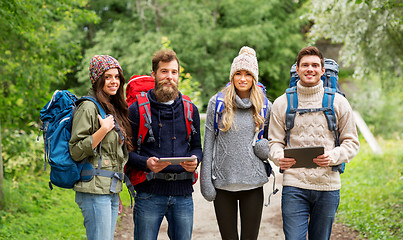 Image showing friends or travelers with backpacks and tablet pc