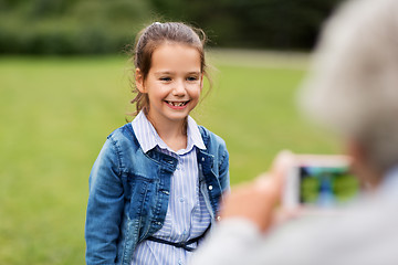 Image showing little girl being photographed at summer park