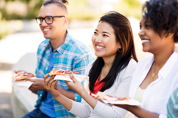 Image showing happy friends eating sandwiches and pizza outdoors