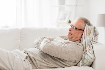 Image showing thoughtful senior man lying on sofa at home