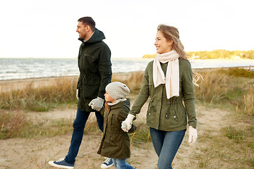 Image showing happy family walking along autumn beach