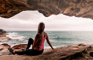 Image showing Woman in active wear sitting by the ocean