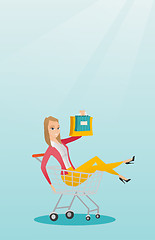 Image showing Young caucasian woman riding in shopping trolley.