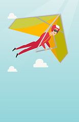 Image showing Young caucasian man flying on hang-glider.