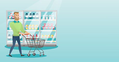 Image showing Young caucasian man with supermarket trolley.