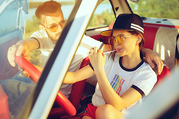 Image showing Laughing romantic couple sitting in car while out on a road trip