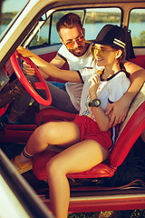 Image showing Laughing romantic couple sitting in car while out on a road trip