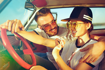 Image showing Laughing romantic couple sitting in car while out on a road trip