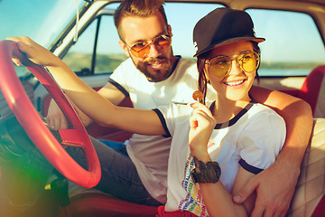 Image showing Laughing romantic couple sitting in car while out on a road trip at summer day