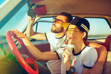 Image showing Laughing romantic couple sitting in car while out on a road trip