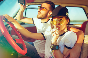 Image showing Laughing romantic couple sitting in car while out on a road trip at summer day