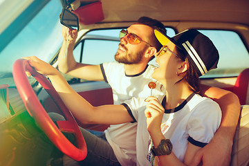 Image showing Laughing romantic couple sitting in car while out on a road trip