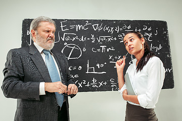 Image showing Male professor and young woman against chalkboard in classroom